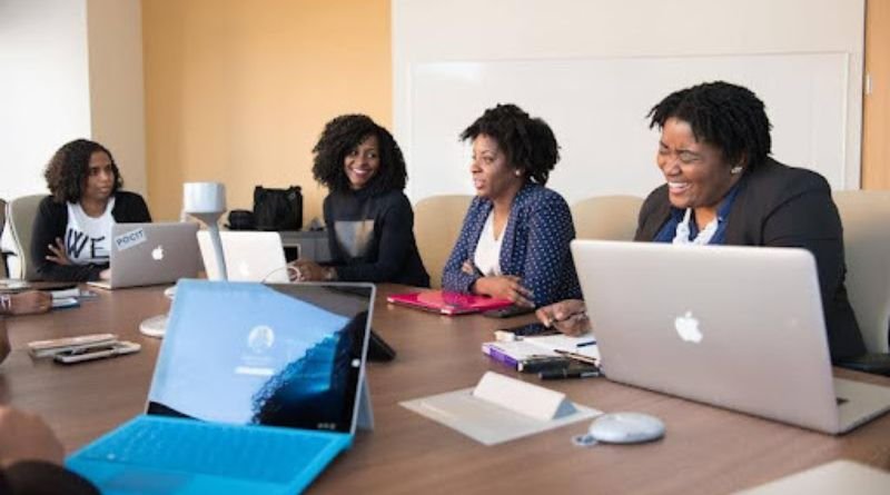 Alt text: A collaborative team meeting with laptops, showcasing streamlined workflows achieved through IT professional services automation.